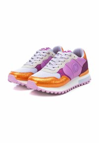 Sneaker colorate con tomaia in rete bianca, dettagli lavanda e particolari arancioni lucidi. Suola spessa bianca con suola esterna viola testurizzata.