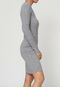 Robe en tricot grise avec une texture côtelée et un motif en maille torsadée, à manches longues et silhouette ajustée, se terminant au-dessus du genou.