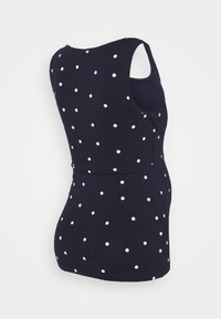 Námořnická modrá top bez rukávů s bílými puntíky vystavený na manekýně, ukazující zadní a boční pohled.