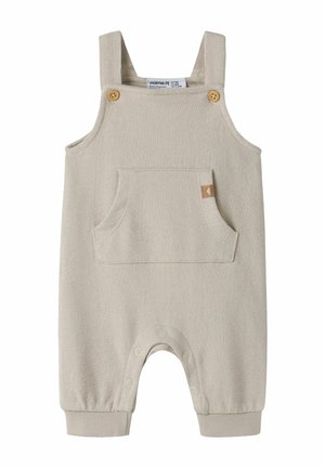 Combinaison sans manches beige pour bébé avec bretelles à boutons en bois, poche avant et pressions le long de la couture intérieure pour un change facile.