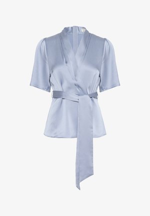 Ljusblå omslagblus med korta ärmar, tillverkad av ett slätt texturerat material. Har ett självknutande bälte och en V-formad halsringning.