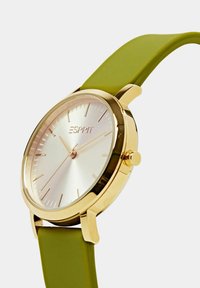 Orologio oro con quadrante argento a raggi di sole, dettagli con indici e cinturino in silicone verde. Presenta un design minimalista e una finitura liscia.