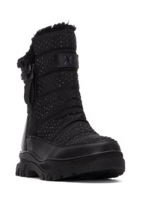 Bota de invierno negra con superficie texturizada, adornada con pequeñas tachuelas, con parte superior de piel sintética, cremallera lateral y suela robusta.