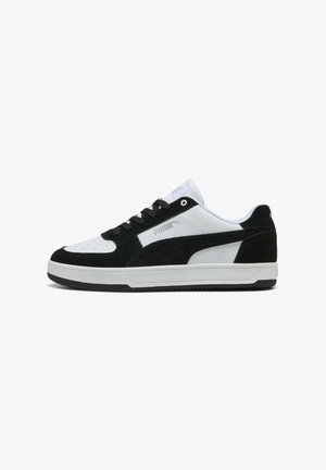 Sneaker bianco e nero con tomaia in suede e pelle, caratterizzate da una punta forata, chiusura con lacci e suola in gomma.