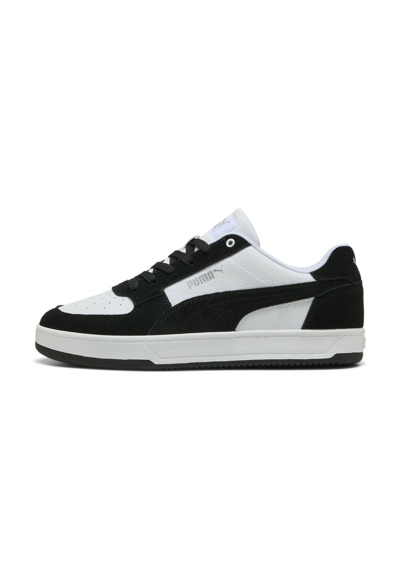 Zapatillas en blanco y negro con una parte superior de ante y cuero, que cuentan con una puntera perforada, cierre de cordones y suela de goma.