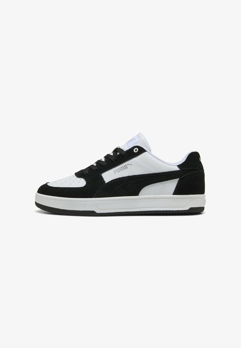 Zapatillas en blanco y negro con una parte superior de ante y cuero, que cuentan con una puntera perforada, cierre de cordones y suela de goma.