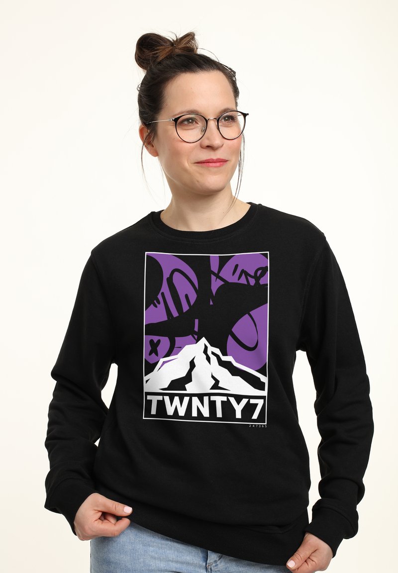 Felpa nera con una grafica di montagna in bianco e viola, con la scritta "TWNTY7" in basso. Tessuto morbido con scollatura a girocollo.