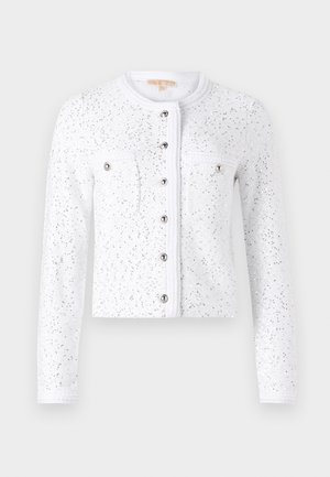 Cardigan blanc à manches longues, col rond, en tissu texturé, avec des sequins argentés, fermeture centrale par bouton, et deux poches poitrine avec des boutons argentés.