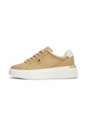 Sneaker beige low-top con suola platform bianca, dettaglio bianco sul tallone, chiusura frontale con lacci e piccolo logo metallico sul lato.