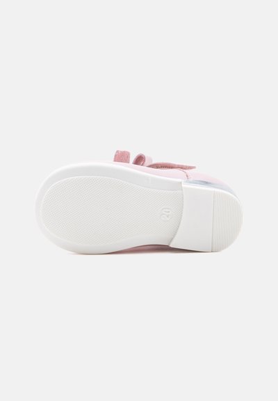 Semelle blanche d'une chaussure rose pour tout-petit avec une surface texturée antidérapante et le numéro de taille 20 visible sur la semelle.