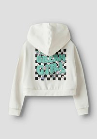 Kort hvit hettegenser med fargerikt «DREAM GIRL»-motiv i et sjakkbrettmønster med blomster og hjerter på baksiden.