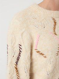 Strickpullover in Creme mit strukturierten Blattmustern. Verfügt über kontrastierende Stickereien in Rosa-, Braun- und Dunkellila-Tönen. Rundhalsschnitt.