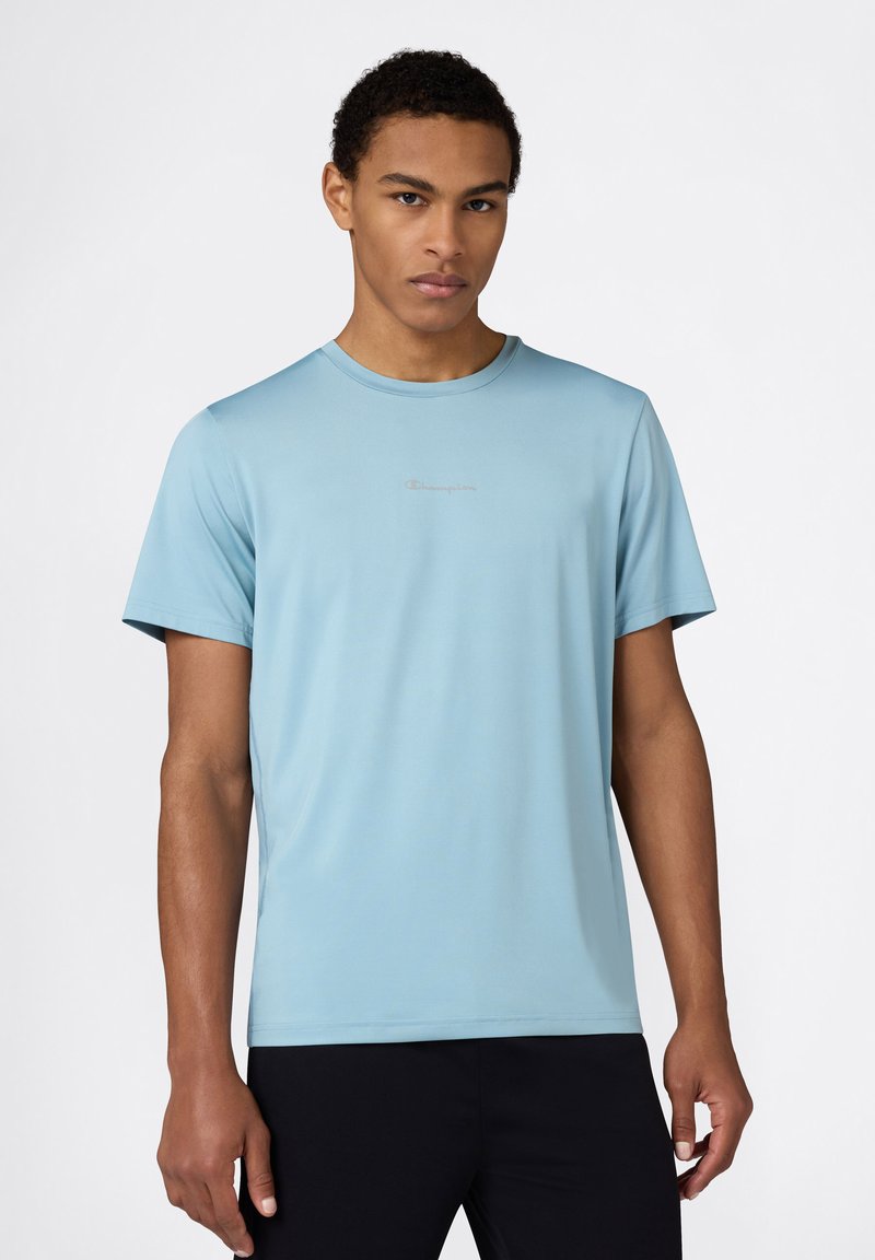 Camiseta de manga corta color azul claro hecha de tela suave, con un escote redondo y un pequeño logo en un tono contrastante en el pecho.