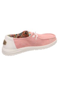 Scarpe da barca in tela rosa con suola bianca, caratterizzate da una tomaia in tessuto testurizzato e una fodera a fantasia colorata. Chiusura con lacci di lato.