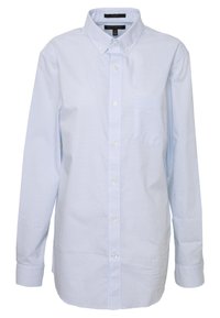 Světle modrá kostkovaná košile s dlouhým rukávem vyrobená z bavlny. Má klasický límec, zapínání na knoflíky a náprsní kapsu na levé straně.