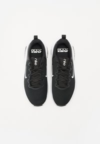 Sneakers in rete nera con accenti bianchi. Le caratteristiche includono lacci, logo sulla linguetta e un design a punta rotonda. Costruzione leggera.