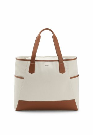 Borsa tote in tela beige con manici, rifiniture e fondo in pelle marrone, dotata di tasche laterali e piccolo logo del marchio centrale.