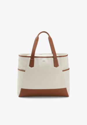 Beżowa torba na płótnie z brązowymi skórzanymi uchwytami, wykończeniem i spodem, z bocznymi kieszeniami oraz małym centralnym logo marki.