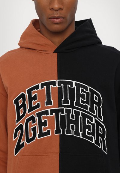 Kapuzensweatshirt mit einem geteilten Design: linke Seite in rostorange und rechte Seite in schwarz, mit "BETTER 2GETHER" in Weiß gestickt.