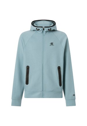 Sweat à capuche zippé bleu clair avec capuche à cordon, accents noirs sur les poches et les poignets, et un petit logo sur la poitrine. Texture douce.