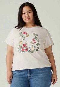 Tricou crem cu mâneci scurte, decorat cu broderie florală și fluturi în roșu, albastru, galben și verde; croială lejeră, decolteu rotund.