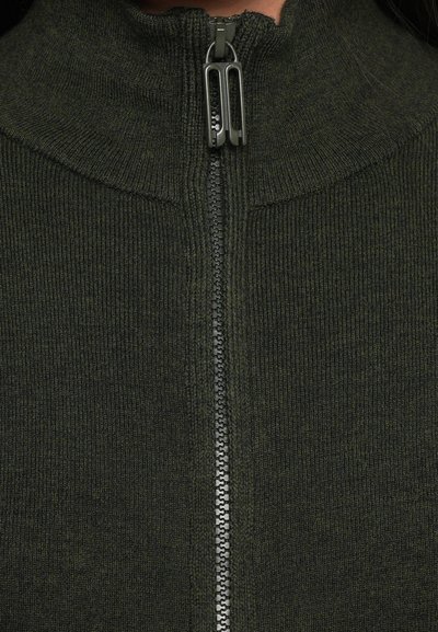 Σκούρο πράσινο, ριπτό πλέ knit πουλόβερ με ψηλό γιακά και φερμούρ πλήρους μήκους που διαθέτει μεταλλικές λεπτομέρειες κατά μήκος του ανοίγματος.