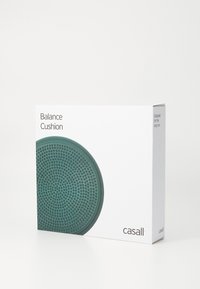 Poduszka balansowa o okrągłym kształcie, teksturowana powierzchnia w kolorze turkusowym, zapakowana w białe opakowanie z czarnym tekstem i szczegółami marki.