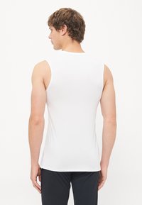White sleeveless athletic shirt, made of a smooth, stretchy material. Features a round neckline and a fitted silhouette.