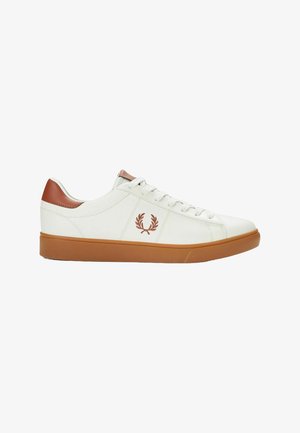 Zapatilla blanca de cuero con un acento de talón de cuero marrón, puntera redonda, suela de goma y logotipo bordado en el costado. Cierre de cordones plano.