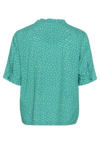 Blusa teal a maniche corte con pois bianchi, polsini delle maniche abbottonati e un piccolo colletto arricciato, vista da dietro.