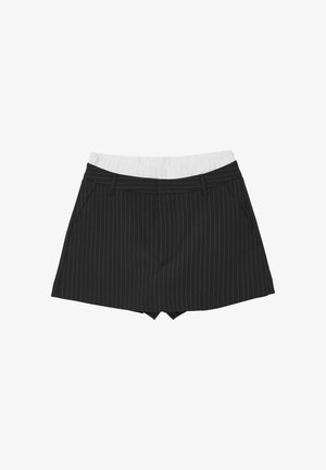 Shorts neri a righe sottili con una cintura elastica bianca, dotati di tasche e un design aderente, realizzati in un tessuto liscio.