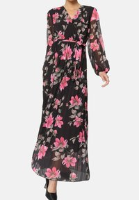 Robe maxi en tissu léger noir avec un motif floral comportant des fleurs roses et grises. Manches longues et détail de taille nouée.