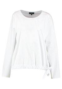 Haut blanc à manches longues en tissu léger. Il présente un col rond, une taille froncée avec un détail noué sur un côté. Texture lisse.