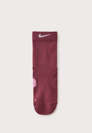 Μαρόν κάλτσα Nike με ανοιχτό ροζ λεπτομέρειες, υφή από δίχτυ και λευκό λογότυπο swoosh κοντά στη μανσέτα, εμφανίζεται επίπεδη και χωρίς ετικέτα σε λευκό φόντο.