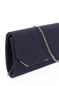 Tmavě modré psaníčko s texturovaným povrchem, stříbrným kovovým lemováním na klopě a stříbrným řetízkovým popruhem na bílém pozadí.