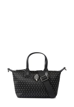 Zwarte handtas met kleine zilverkleurige studs, twee korte handvaten, een afneembare brede schouderriem en een decoratief zilveren embleem aan de voorkant.