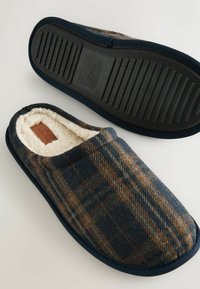 Marineblå og brunternet sutsko med blødt hvidt fleecefor, gummisål og buet design for komfort. Størrelse trykt på sålen.