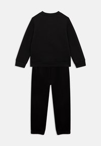 Sort langærmet sweatshirt og matchende bukser sæt med ribbede manchetter, set fra ryggen mod en hvid baggrund.