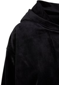 Crna baršunasta hoodie s mekanom teksturom, koja ima visoki ovratnik i drapirani dizajn, prikazujući glatku, neukrašenu tkaninu.