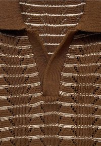 Hnědý pletený svetr s výstřihem do V a střídavými krémovými a hnědými pruhy. Obsahuje krajkové vzory a žebrovaný detail u límce.