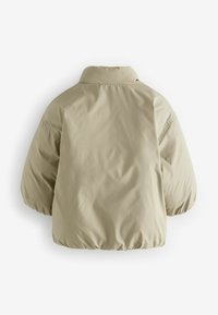 Beige puffjacka med kort krage, breda ärmar och dragsko i nederkant. Slätt, lätt material; minimalistisk design utan dekorationer.