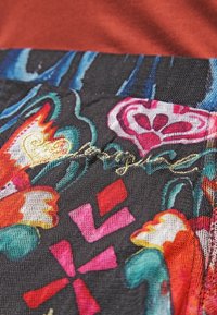 Tessuto colorato con motivi floreali e astratti in rosa, rosso e blu su uno sfondo scuro, con dettagli in ricamo dorato.