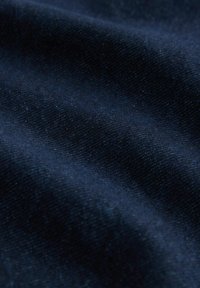 Mörkblått tyg med en slät textur, som uppvisar subtila variationer i vävning och djup, vilket skapar ett rikt, mörkt utseende.