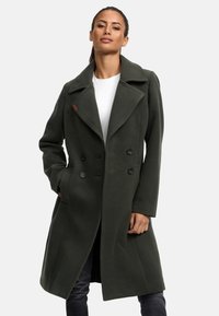 Olive green double-breasted coat made of wool blend, featuring large lapels, two side pockets, and dark buttons. Smooth texture and tailored fit.