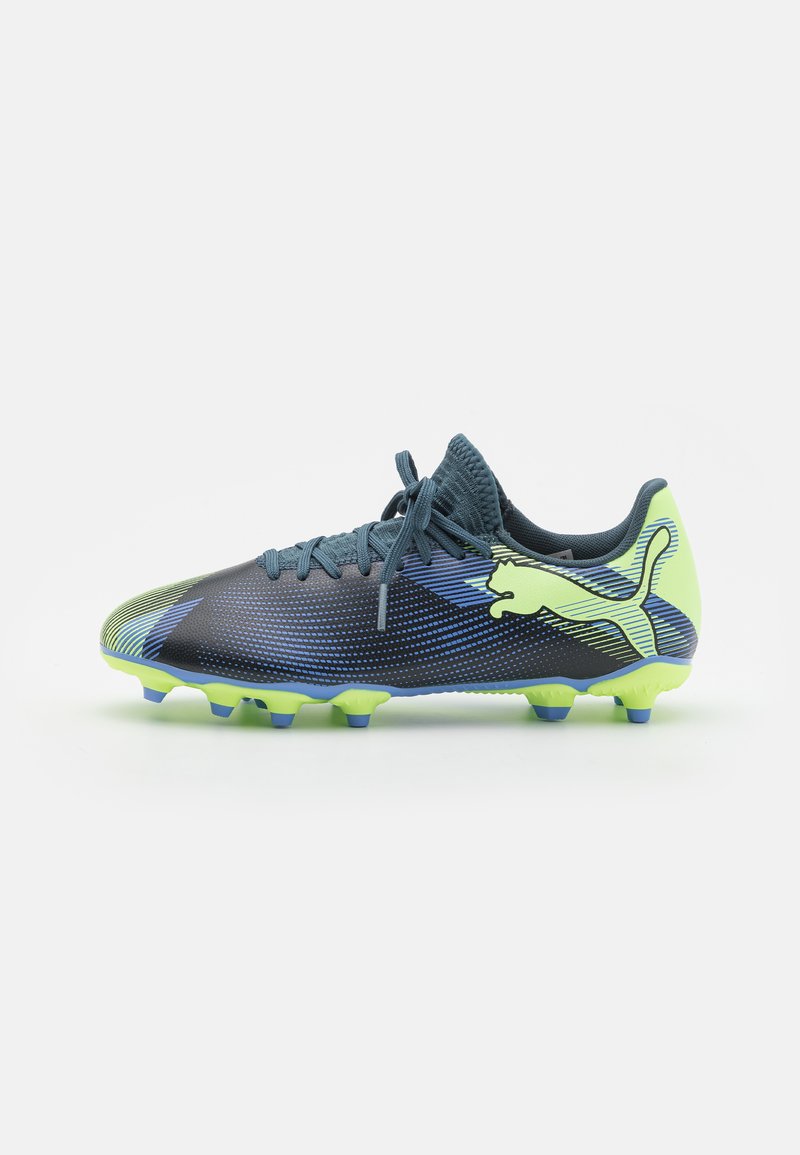 Botas de fútbol con un diseño elegante en azul oscuro y verde neón, que cuentan con una parte superior texturizada, cierre de cordones y tacos puntiagudos para mayor tracción.