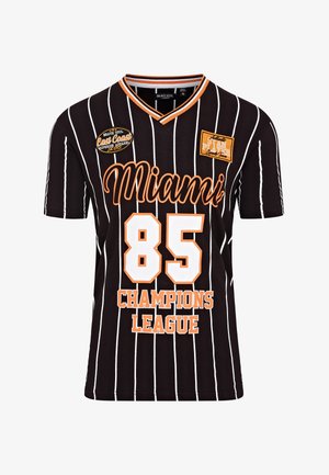 Czarny krótki rękawowy T-shirt z białymi pionowymi paskami. Z przodu znajduje się napis "Miami" oraz "85 CHAMPIONS LEAGUE" w kolorze pomarańczowym, z haftowanymi naszywkami.