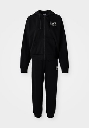 Zwarte zip-up hoodie en bijpassende joggingbroek met witte EA7 Emporio Armani-logo's op de borst en de dij, weergegeven op een witte achtergrond.