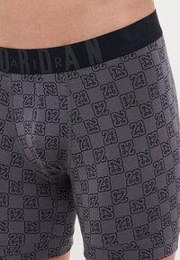 Boxeri gri, cu un model repetitiv negru "23". Brâu elastic negru cu logo-ul "JORDAN". Material moale și elastic.