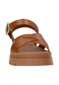 Bruine synthetische sandalen met een breed kruisbandontwerp, verstelbare gesp en een dikke, gestructureerde zool. Versterkt met een subtiele platform.