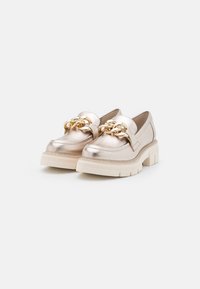 Metallisch goldene Slipper mit einer klobigen, cremefarbenen Sohle, ausgestattet mit einem dekorativen goldenen Kettendetail über dem Obermaterial und einer glatten Lederoberfläche.